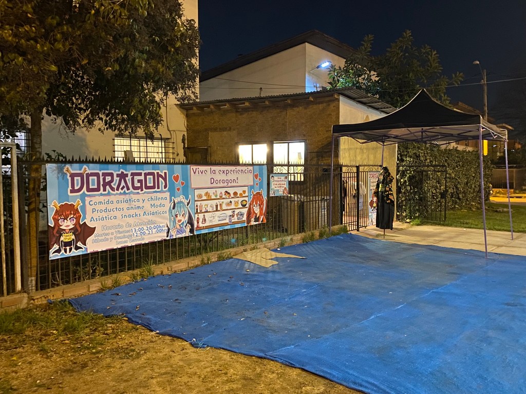 La entrada a Doragon Maid Café, ya de noche, en Maipú.