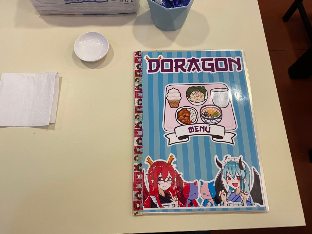 Sobre la mesa, el menú de Doragon Maid Café.